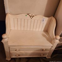 Full view of cream wood bench showing backrest, arm posts, drawers and knobs