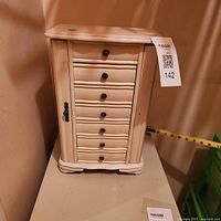 Front view of closed jewelry box showing six drawers and side panels