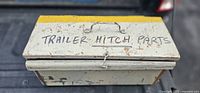 closed wooden box labeled trailer hitch parts