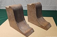 front angled view of both oak corbels showing curved profile and surface wear