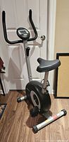 Full view of PT Fitness upright stationary bike showing frame, seat, pedals and flywheel housing