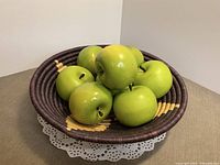 Basket filled with seven faux green apples