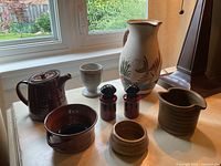 All eight pottery pieces displayed together on table