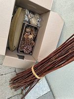Box showing boat-shaped tray, wooden box with pine cones, decor balls, bundle of branches