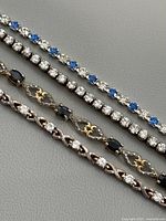 Four bracelets laid flat to show stone patterns and links