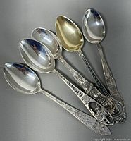 Group of five sterling silver souvenir spoons fanned out
