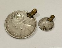 Obverse of both coin pendants with brass bails visible