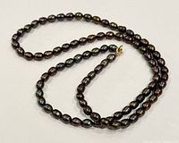 Full view of necklace laid out showing bead shape and clasp