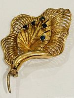 Front view showing leaf design, blue stones, gold finish