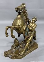 Front view of bronze sculpture showing horse rearing and groom holding reins