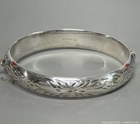 Interior of bracelet showing Sterling mark and Burkhardt hallmark plus floral exterior pattern