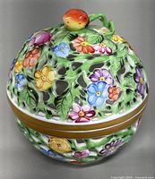 Closed trinket box showing full floral design and finial