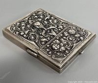 Front angled view of ornate silver case