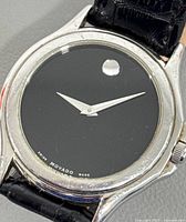 Front view showing black museum dial, single dot, hands, case condition