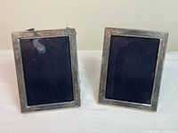 Front view of the two sterling silver picture frames standing upright