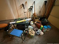 Overall lot showing long-handled tools, stool, light fixture, planters, tubs and containers
