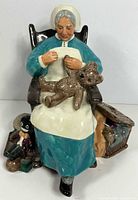 Front view of Royal Doulton “Nanny” figurine showing rocking chair, woman, teddy bear and toys