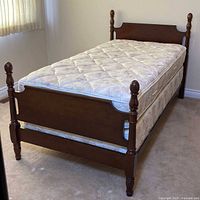 Complete twin poster bed assembled with mattress and box spring