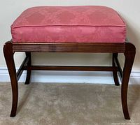 Front view showing cushion, wood frame and curved legs