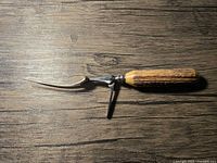 Full view of carving fork showing tines, steel shaft, folding leg and antler handle