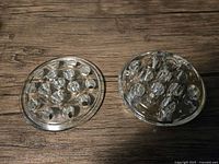 Top view of both clear glass flower frogs showing hole patterns
