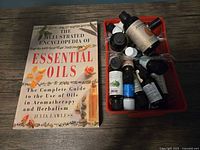 Reference book and basket of essential oil bottles on table