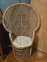 Full view of wicker peacock chair with cushion