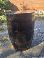 Full view of dark-stained oak barrel with glass top outdoors