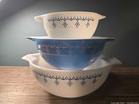 Three nested Pyrex Cinderella bowls showing exterior Snowflake Garland pattern