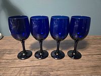 Front view of four cobalt blue wine glasses lined up