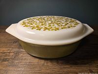 Side view of olive green casserole with patterned lid
