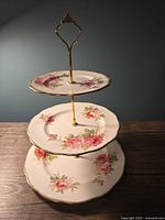 Full view showing three porcelain plates and gold-tone handle