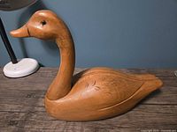 Left profile of hand-carved wood duck on tabletop
