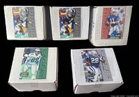 Five closed white card boxes each with sample 1995 Skybox Premium NFL cards affixed