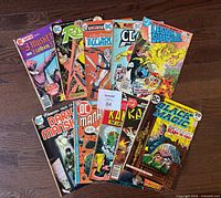 All ten comics fanned out on hardwood floor displaying covers