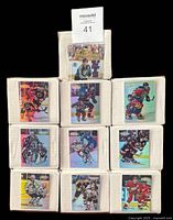 Front view of stacked boxes, each showing sleeved card from the set