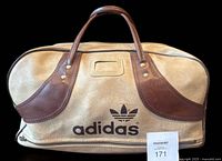 Front of beige Adidas gym bag showing logo, handles, front pocket