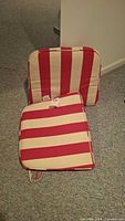 Two striped chair cushions on carpet