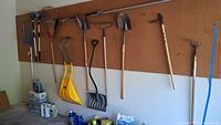 Wide view of pegboard wall showing fishing net, rakes, shovels and snow shovels