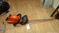 Full view of orange Black & Decker hedge trimmer showing blade and handle