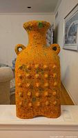 Front view of rectangular orange studded terracotta floor vase with loop handles and flared rim