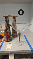 Pair of Robert Weiss candlesticks and Momo Panache glass decor on shelf