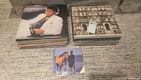 Two stacks of LP albums, Michael Jackson and Led Zeppelin on top, small 7-inch record in foreground