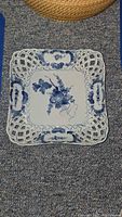 Top view showing square plate, blue floral center, lattice rim