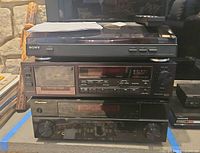 Stacked view of Sony turntable on Denon tape deck on Pioneer receiver, remote and manual visible