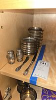 Lot overview on shelf: stacked coasters, two spreaders, salt & pepper shakers