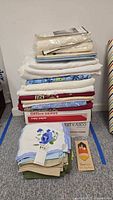 Overall lot showing stacked tablecloths on copy paper box, placemat set and napkin stacks