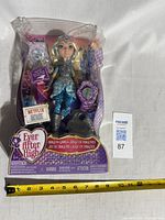 Front view of sealed Ever After High Darling Charming doll package with measuring tape