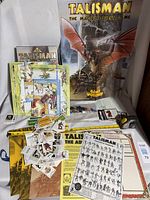 Overall layout of game components including board, rulebook poster, cards, sheets, plastic pieces