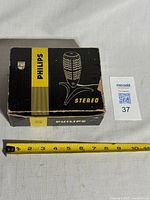 Closed Philips microphone box with measuring tape for scale